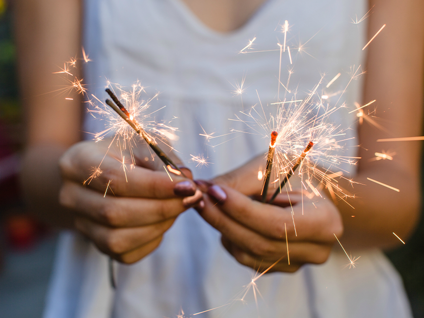 A woman holding lit sparklers
