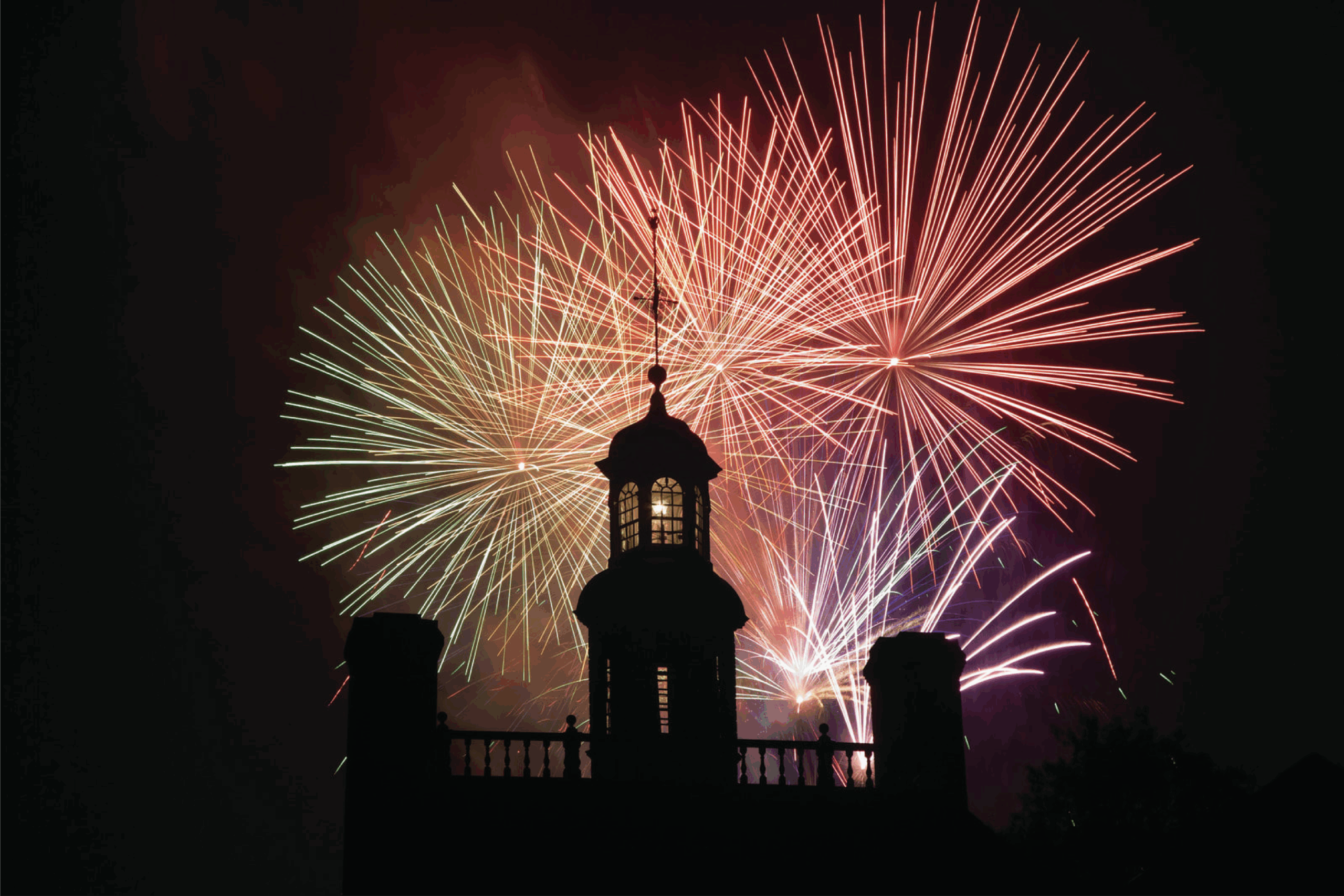 Fireworks at night behind a pergola